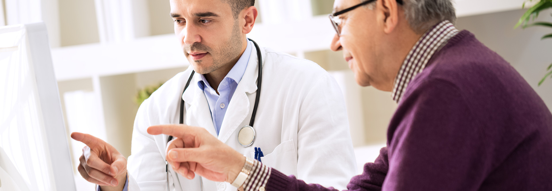 Doctor and patient pointing to a computer screen